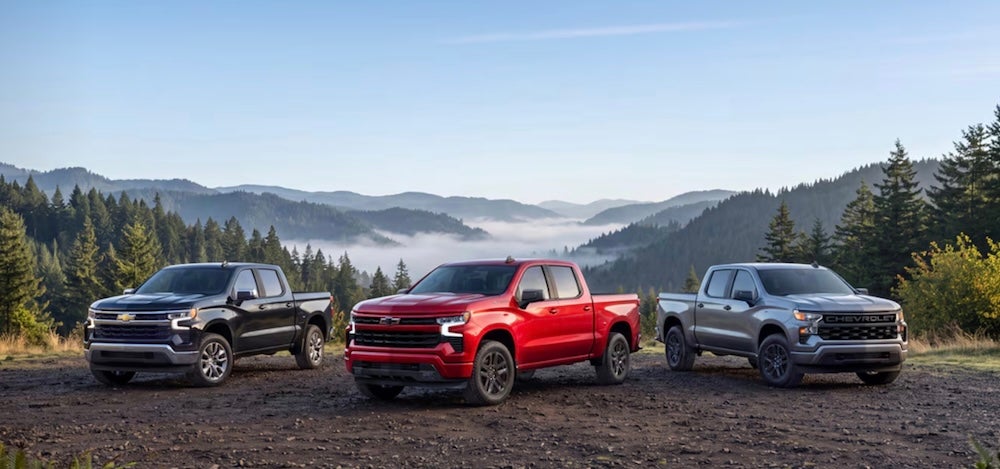 Three Chevrolet pickup truck parked in the mountains